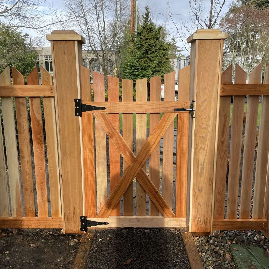 Cedar picket fence and gate with capped posts and black hinges