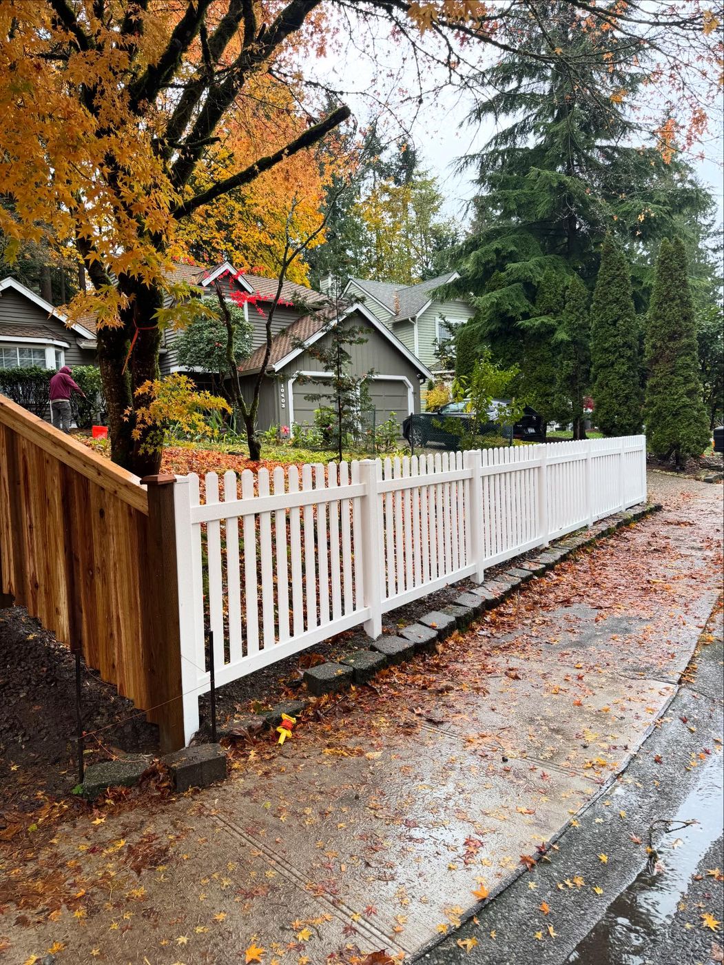 White vinyl picket fence along a driveway